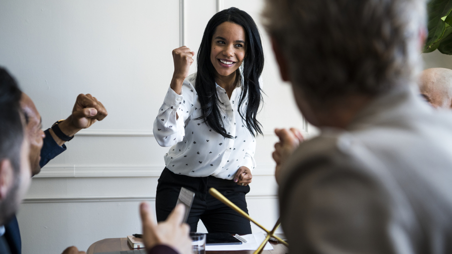 Businesswoman motivating her team members in a meeting